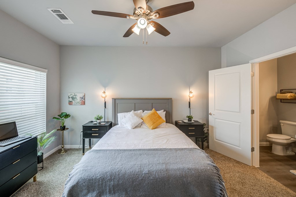 a bedroom with a large bed and a ceiling fan