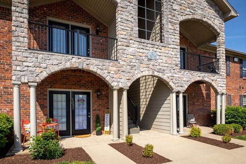 a brick building with three archways and a sidewalk