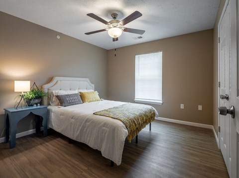 a bedroom with a ceiling fan and a bed