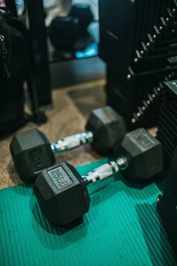 two dumbbells on the floor of a gym