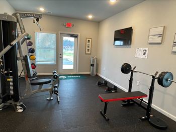 a gym with exercise equipment and a tv