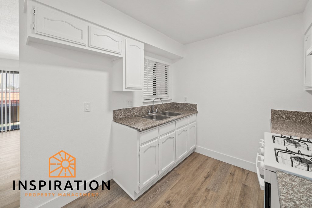 a kitchen with white cabinets and a counter top and a sink