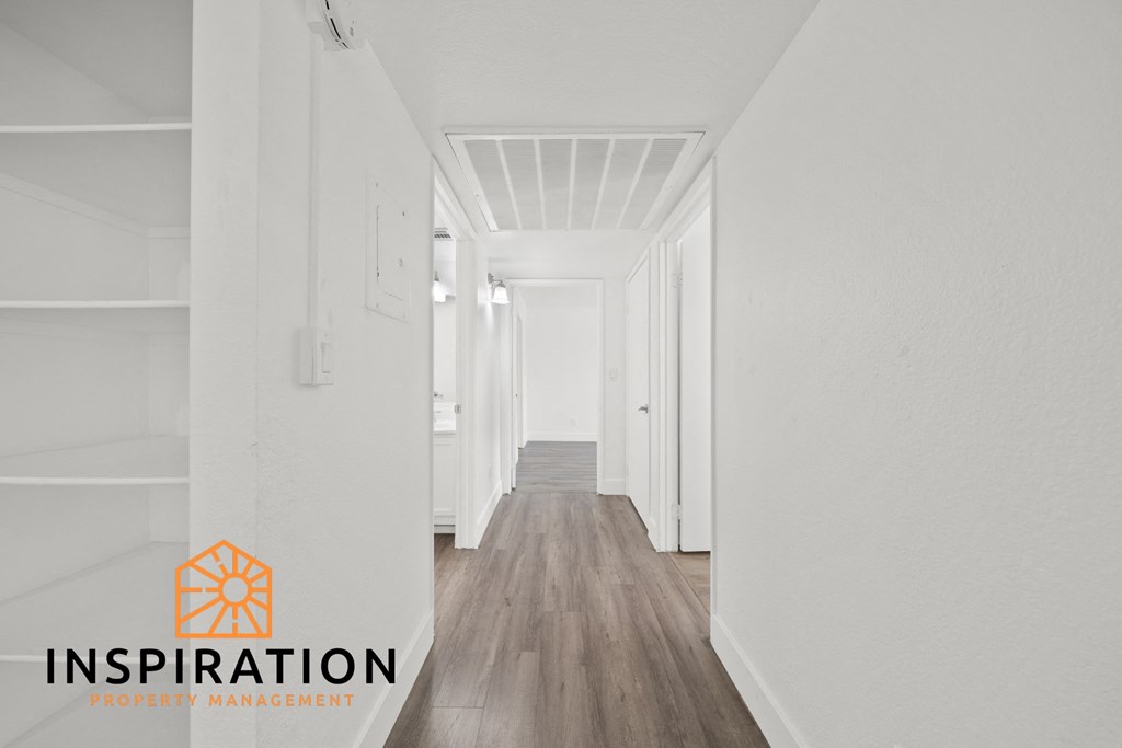 a white hallway with white walls and white floors and a logo for inspiration