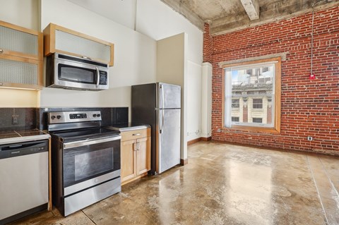 A kitchen with a black stove top oven and a black refrigerator.