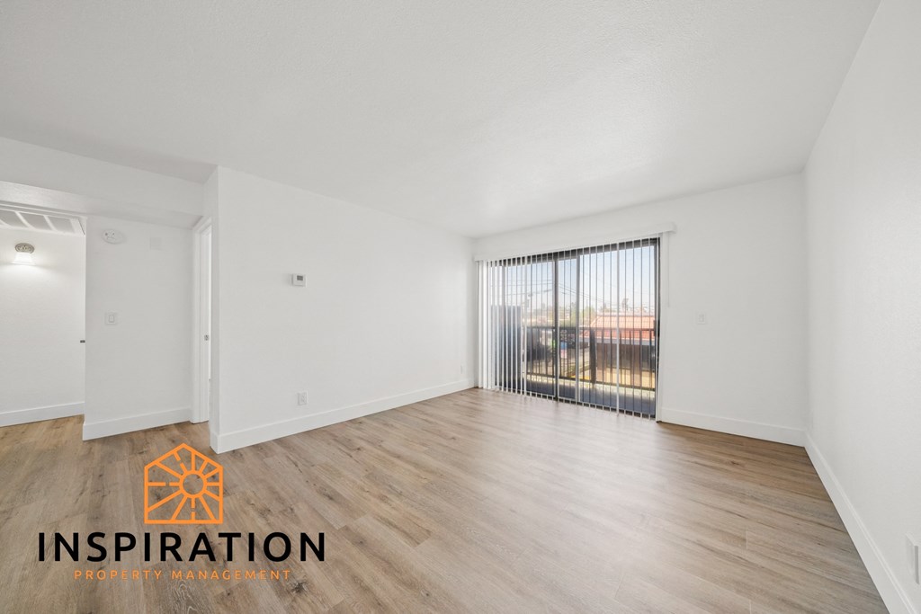 the spacious living room with wood flooring and sliding glass doors