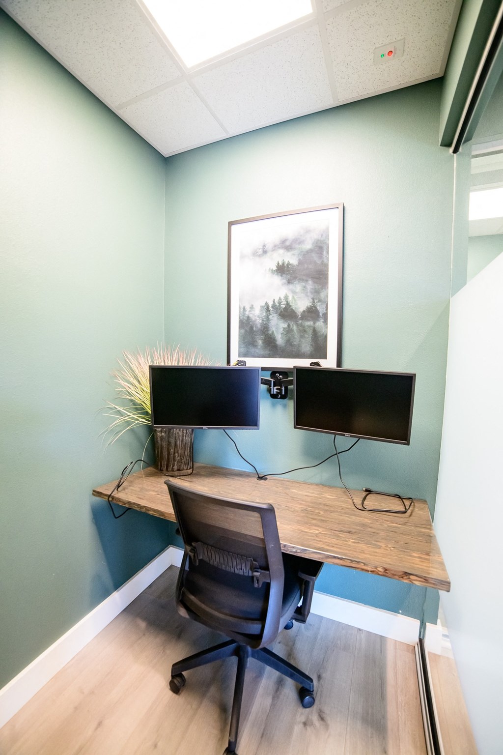 a home office with a desk and two monitors