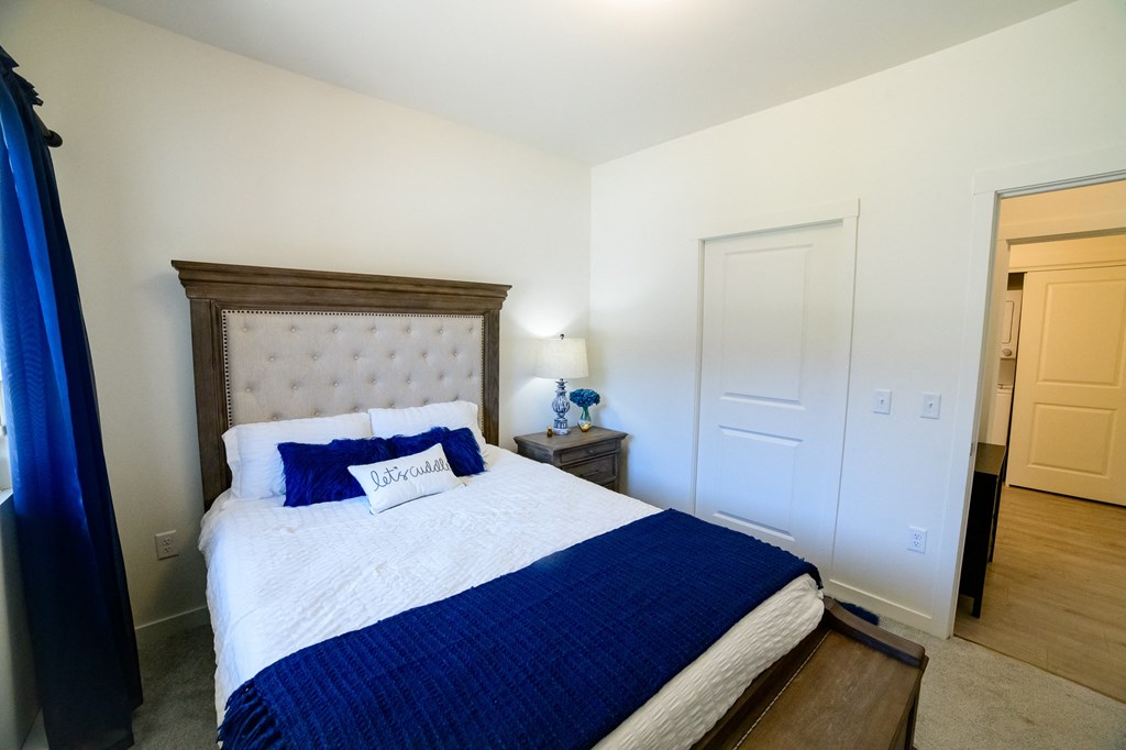 a bedroom with a large bed and a blue blanket and pillows
