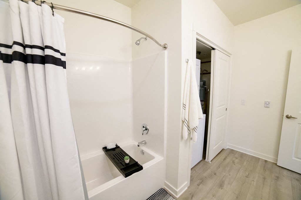 a white bathroom with a shower and a tub and a shower curtain