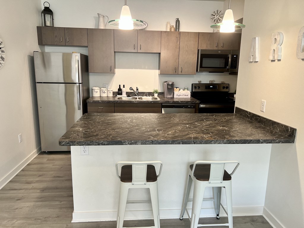 a kitchen with a counter top with two stools