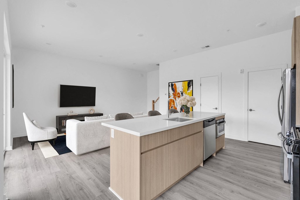 a kitchen and living room with white walls and wood floors at The Franklin Marlboro Apartments, Marlboro, NJ