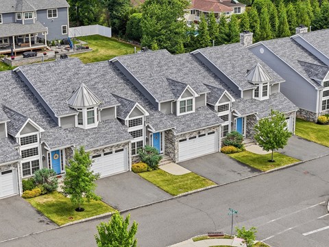 A row of houses with grey roofs and white windows.