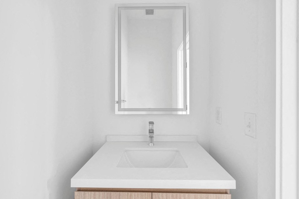 A white sink with a silver faucet and a mirror above it at The Franklin Marlboro Apartments, Marlboro, NJ 07746