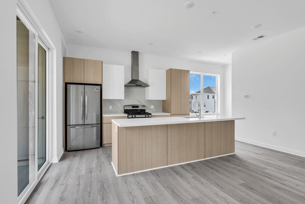 A modern kitchen with a stainless steel refrigerator and a wooden island at The Franklin Marlboro Apartments, Marlboro, NJ