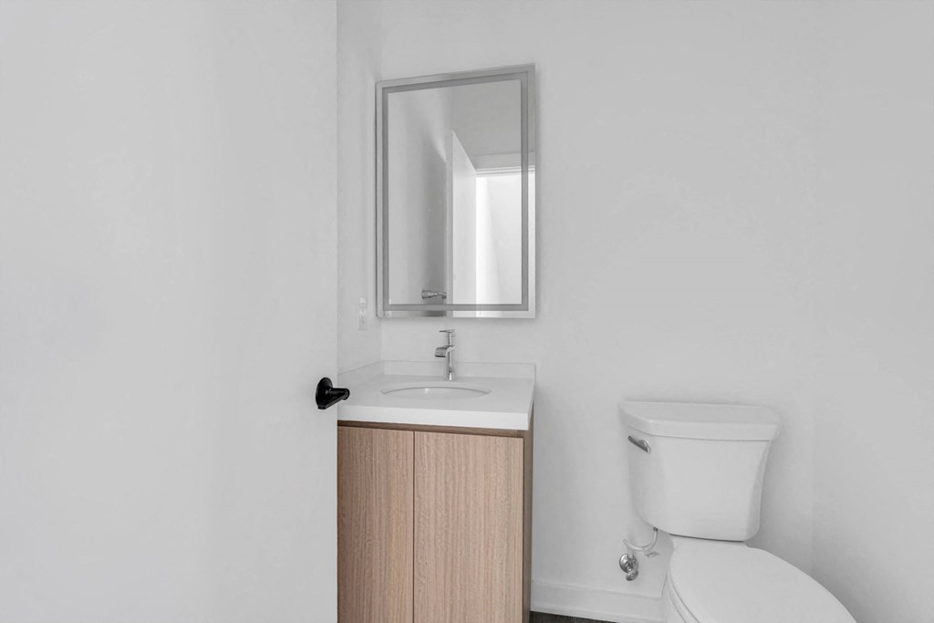 a bathroom with a toilet sink and a mirror at The Franklin Marlboro Apartments, New Jersey, 07746