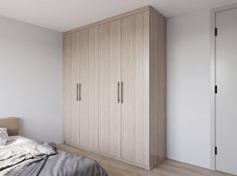 A bedroom with a bed, wardrobe and a door.