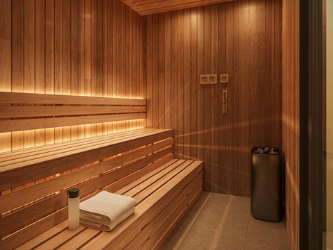 A wooden sauna with a towel and a container on the bench.