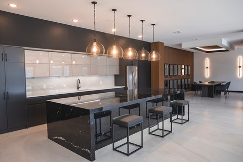 A modern kitchen with black and white decor and a bar area.at The Franklin at Westfield, New Jersey