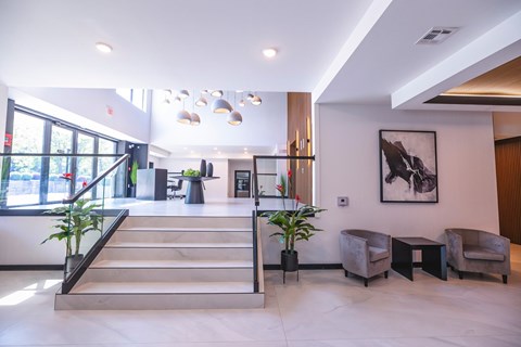 A spacious lobby with a staircase, chairs, and a large painting on the wall.at The Franklin at Westfield, New Jersey, 07090