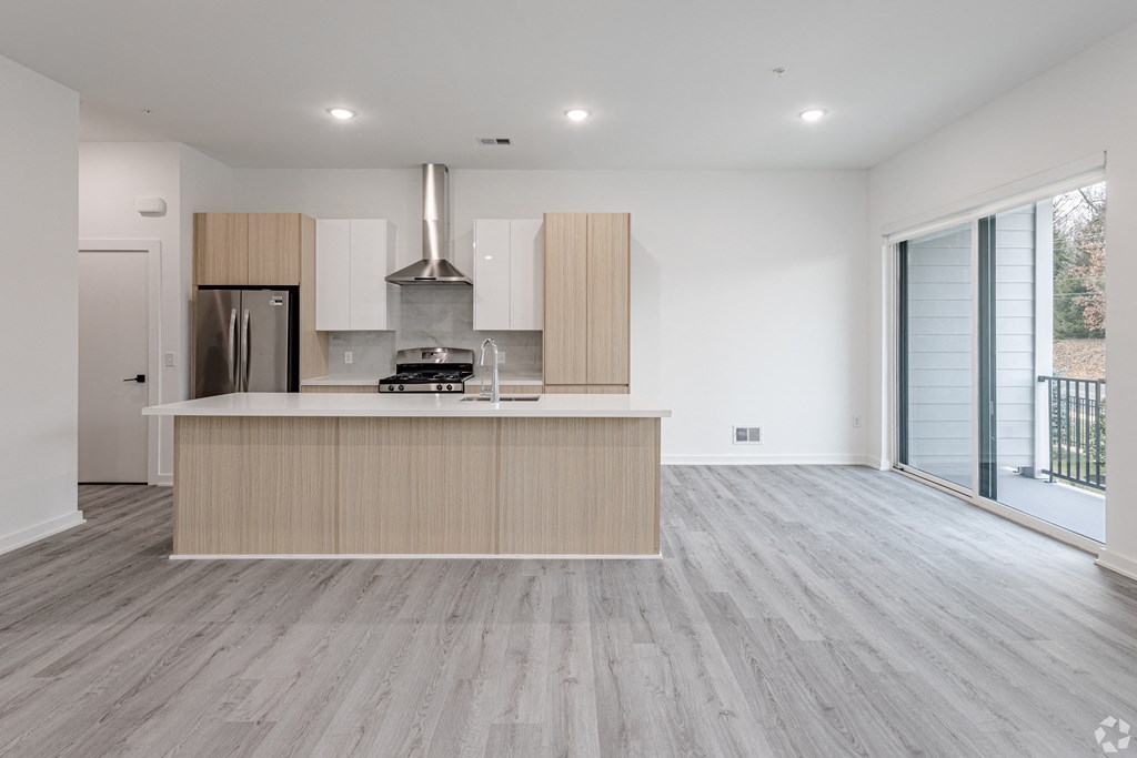 A modern kitchen with a stainless steel refrigerator and a wooden island. at The Franklin at Marlboro, New Jersey