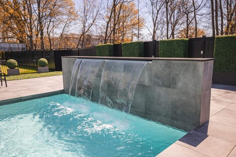 the pool has a water feature with a waterfall