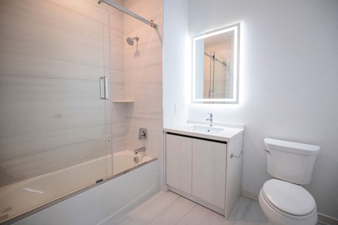 a white bathroom with a shower toilet and sink at The Franklin at Westfield, New Jersey