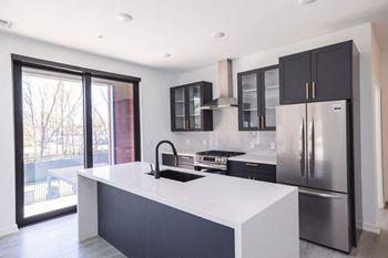 a kitchen with a white counter top and a stainless steel refrigerator