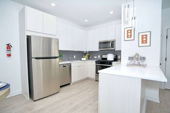 a kitchen with white cabinets and a stainless steel refrigerator