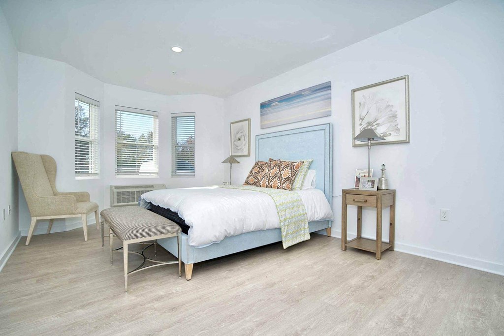 a bedroom with a bed and a chair and a table