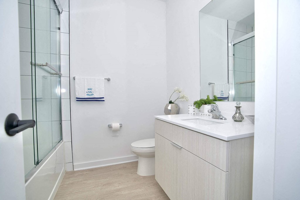 a white bathroom with a shower and a sink