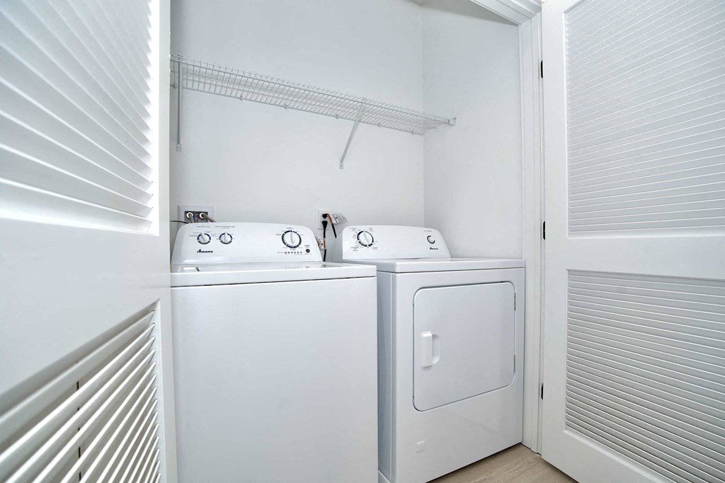 a washer and dryer in a laundry room with a white door