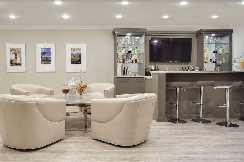 a living room with chairs and a bar and a television