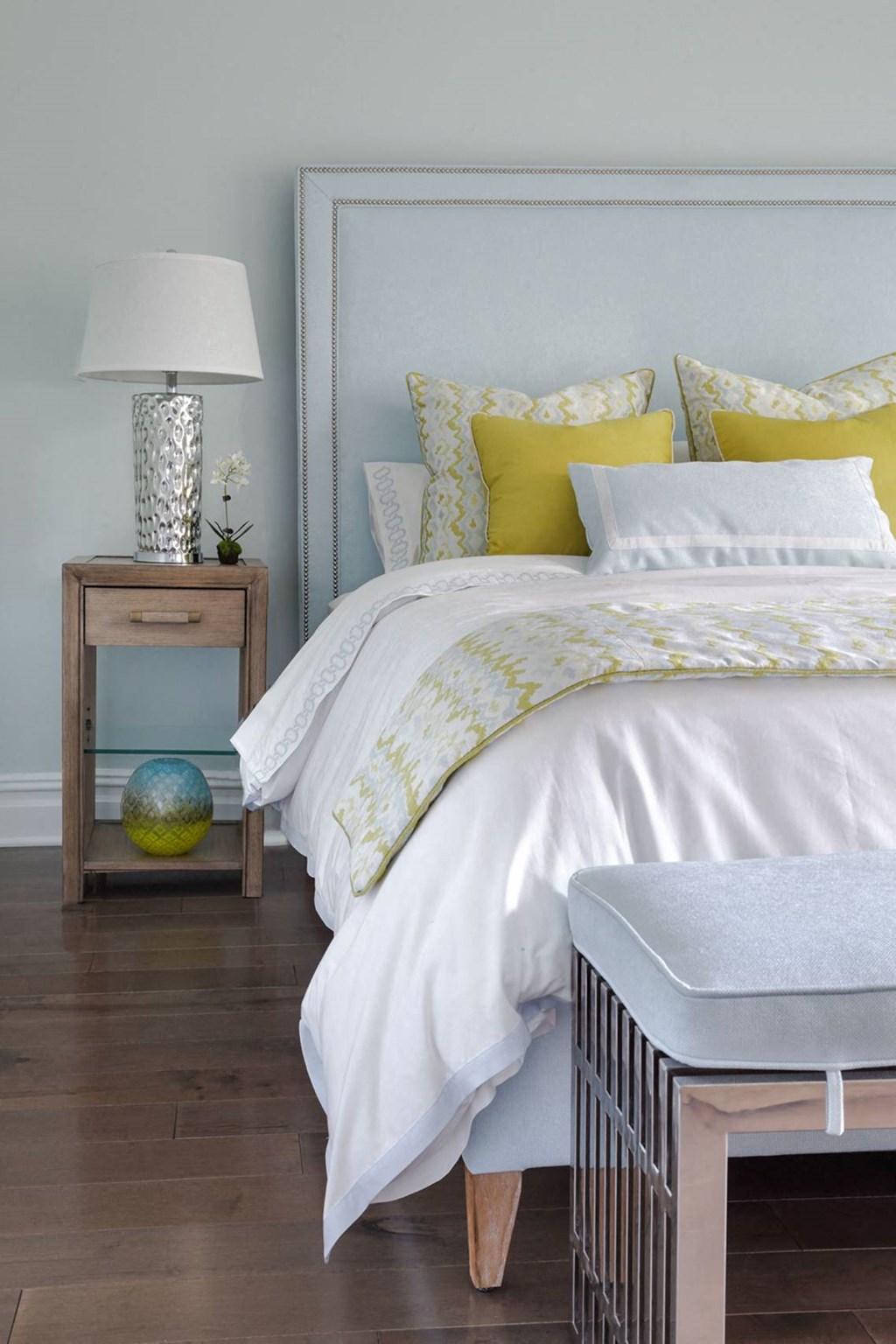 a bedroom with a white bed and yellow and white bedding