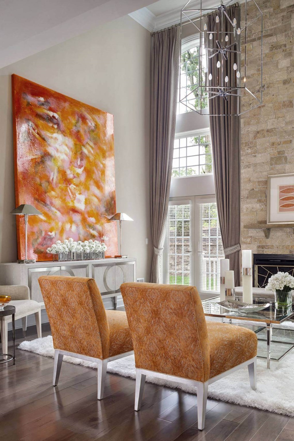 a living room with two orange chairs and a fireplace
