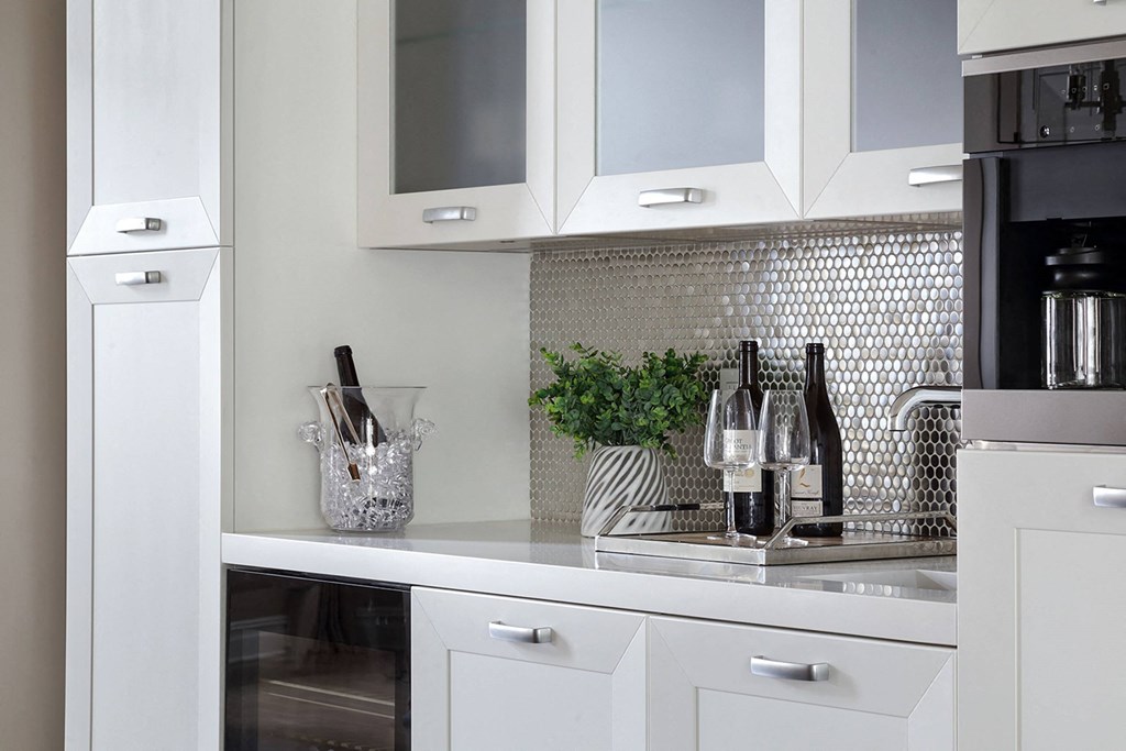 a white kitchen with white cabinets and a sink