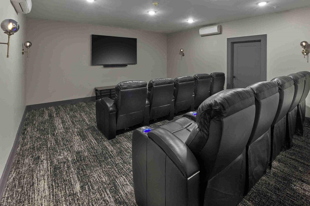 a large screening room with leather chairs and a tv
