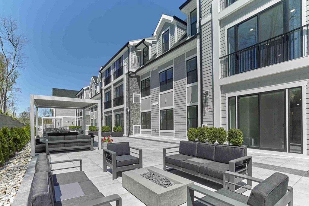 a patio with couches and chairs in front of a building