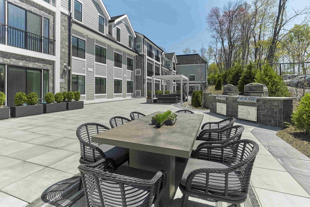 a patio with a table and chairs in front of a building