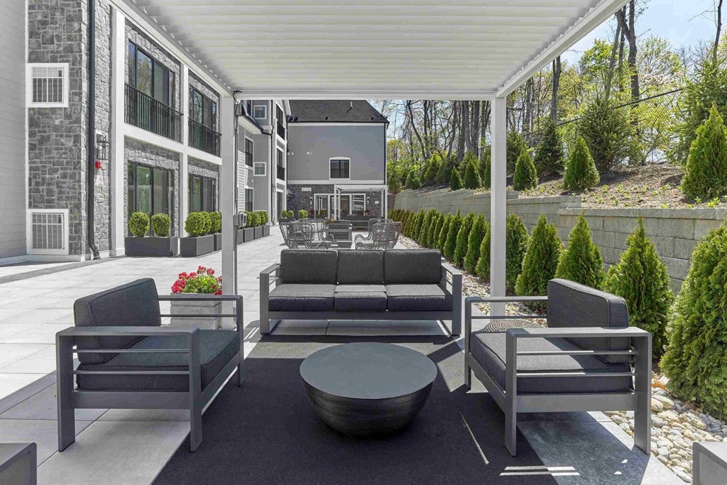 a covered patio with couches and chairs and a table