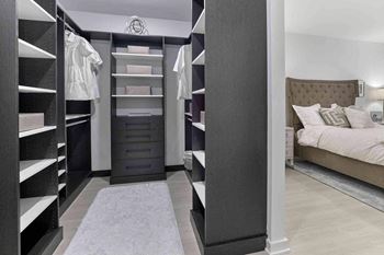 a walk in closet with a bed and a dresser