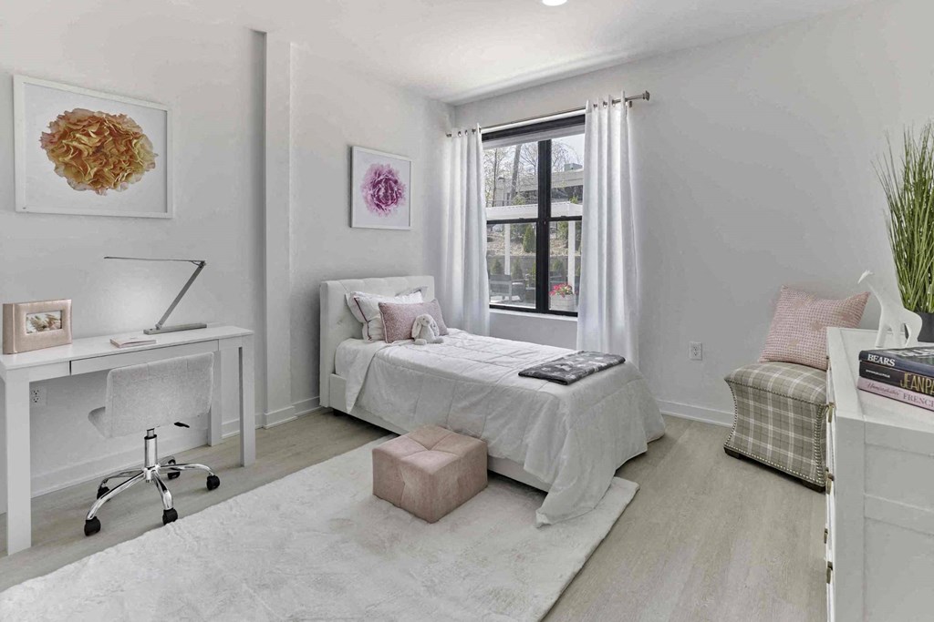 a white bedroom with a bed and a window