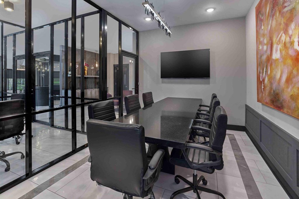 a dining room with a table and chairs and a tv on the wall