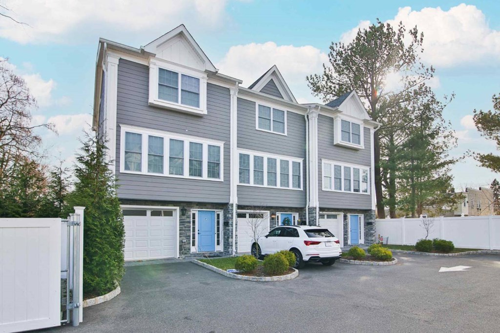 a large gray house with a white car parked in front of it