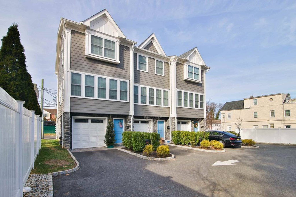 the front of a house with a driveway and a car garage