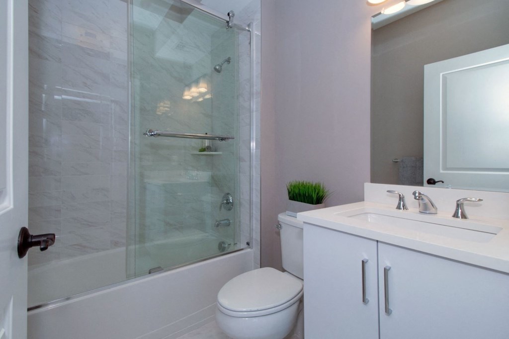 a bathroom with a shower and a sink and a toilet