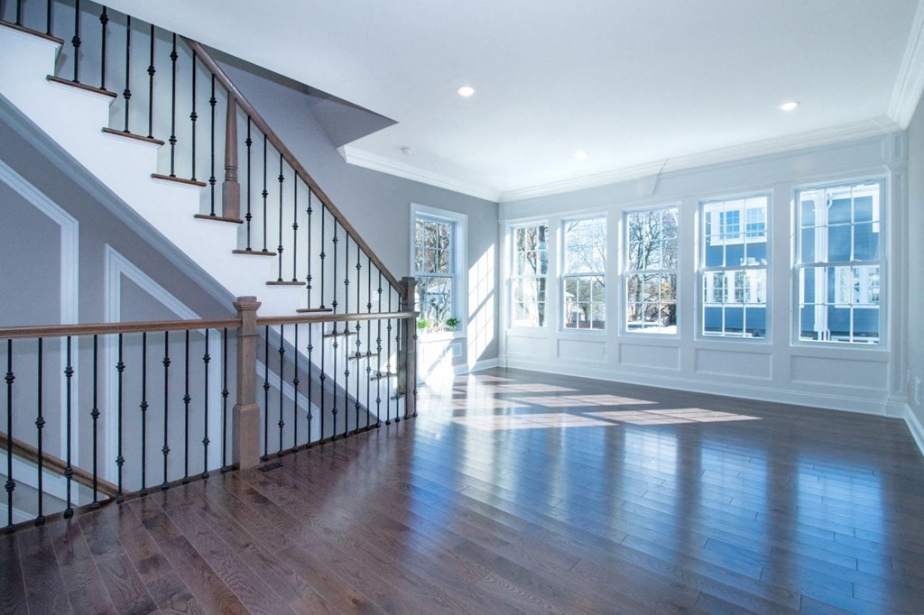 a living room with a staircase and a hard wood floor
