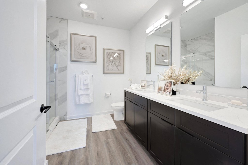 a white and black bathroom with a shower and sink