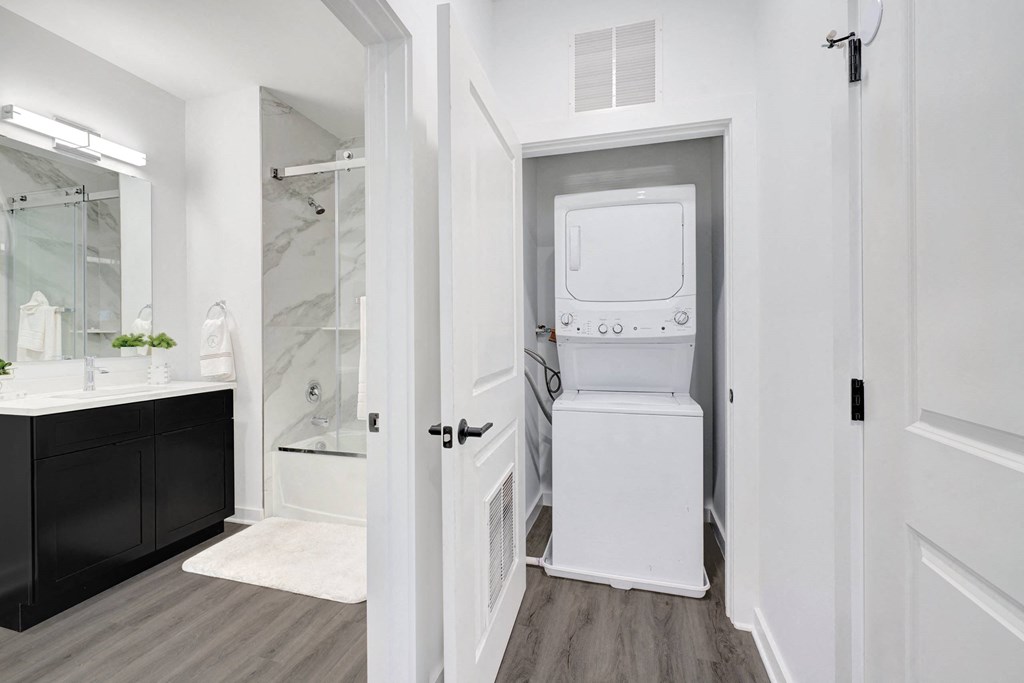 a white bathroom with a washer and dryer in the door