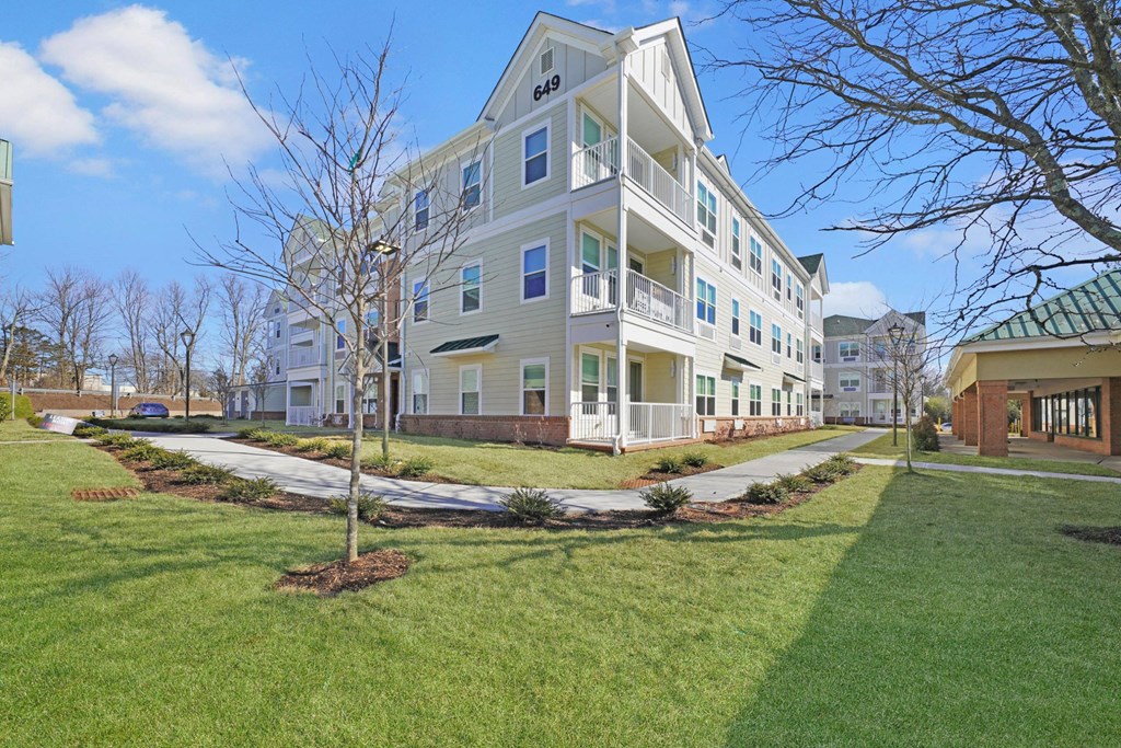 a large apartment building with a lawn and sidewalk in front of it a large apartment building with a lawn and sidewalk in front of it at The Franklin at Hillsborough Apartments, Hillsborough, NJ 08844