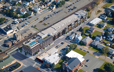 A parking lot is located in front of a building with a green roof.