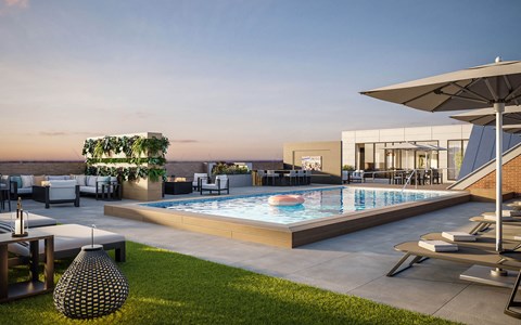 A modern outdoor pool area with lounge chairs and a hanging plant.